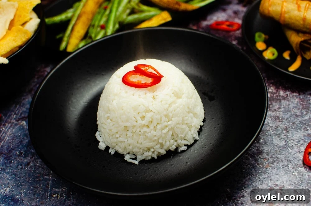 Authentic Jasmine Sticky Rice Recipe from Thailand 12 Jasmine Sticky Rice served in a black bowl with sliced red chilli on top