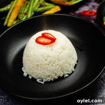 Authentic Jasmine Sticky Rice Recipe from Thailand 3 Jasmine Sticky Rice served in a black bowl with sliced red chilli on top