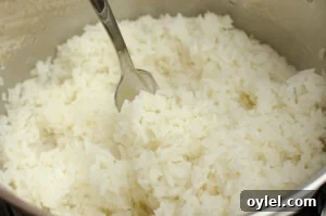 Authentic Jasmine Sticky Rice Recipe from Thailand 8 Fluffing the rice up with a silver fork before serving