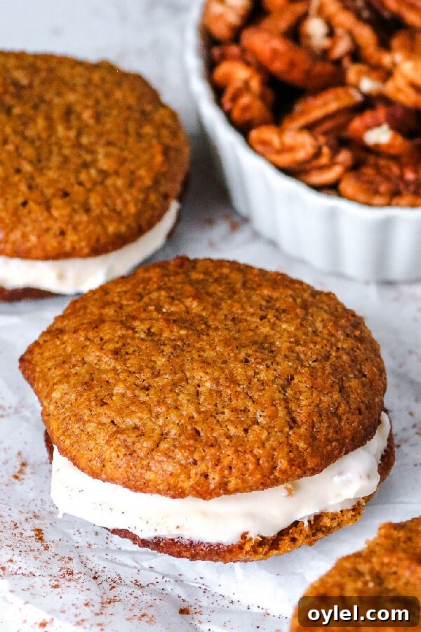Keto Pumpkin Whoopie Pies with Cream Cheese Filling 5 finished cookies with a bowl of pecans