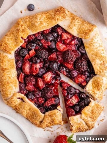 A mixed berry galette with a slice cut out.