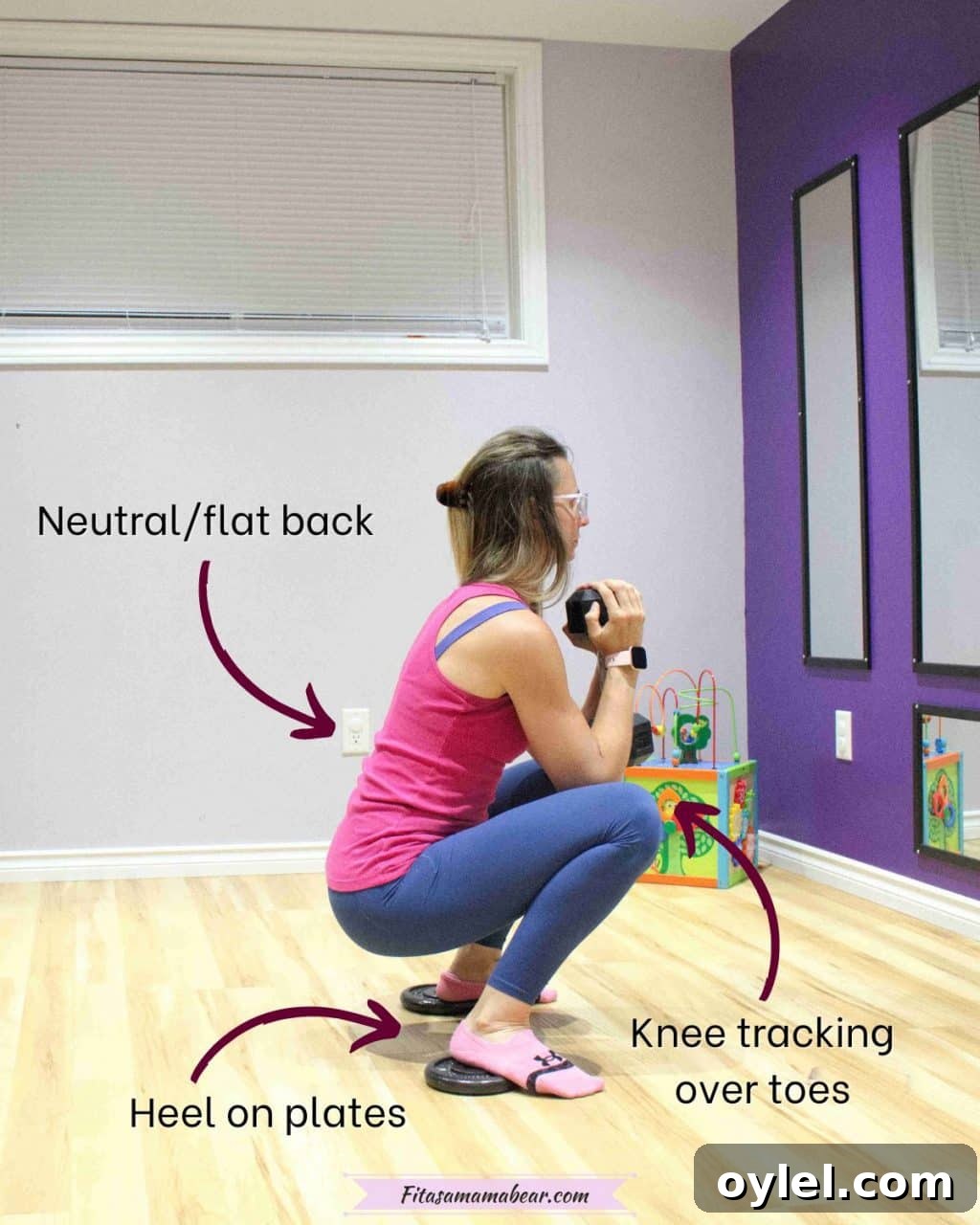 Woman in blue pants and a pink shirt performing a squat with a dumbbell and her heels elevated on weight plates with text and arrows around to give pointers
