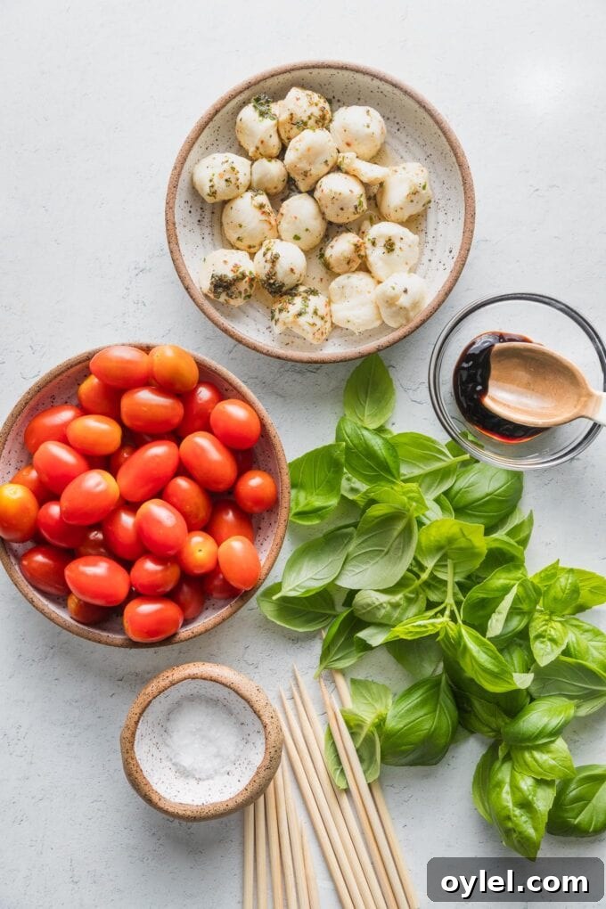 Caprese Skewers with Balsamic Glaze 2 Overhead image of cherry-sized mozzarella balls, cherry tomatoes, lots of fresh basil, skewers, sea salt, and balsamic glaze.