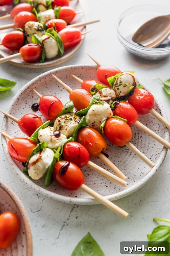 Caprese Skewers with Balsamic Glaze 4 Angled view of small plates loaded up with Caprese skewers.