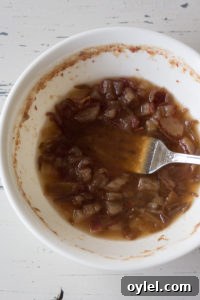 a fork mashing up dates in a bowl of water