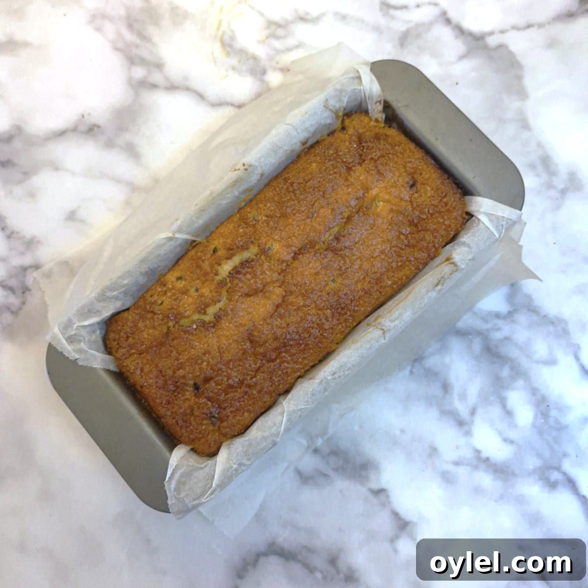 A baked coconut loaf cake in a baking pan.