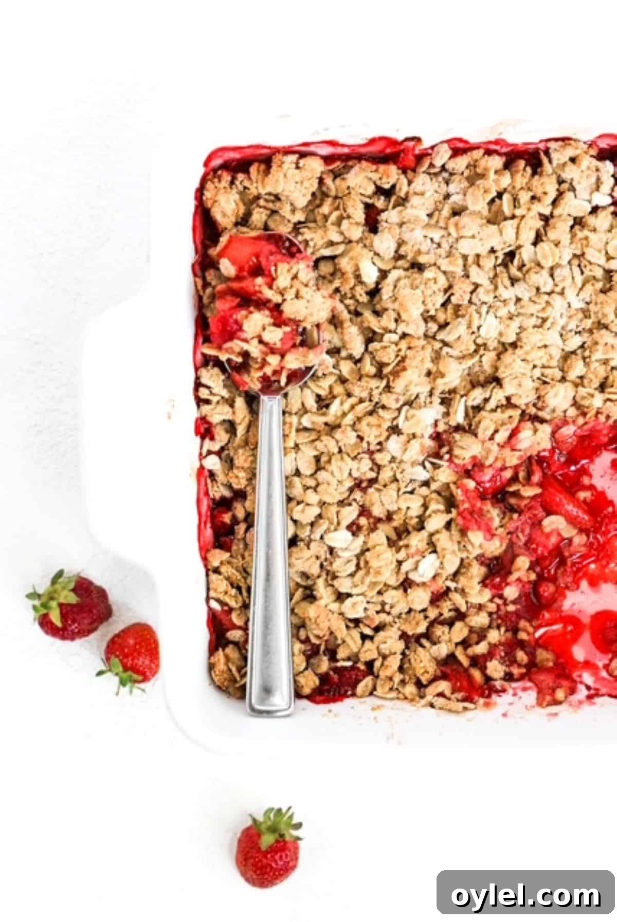Top view of baked Strawberry Crumble with a serving spoon.