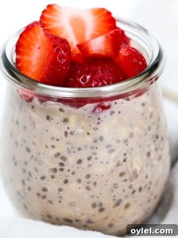 Chocolate overnight oats in a glass jar topped with strawberries.