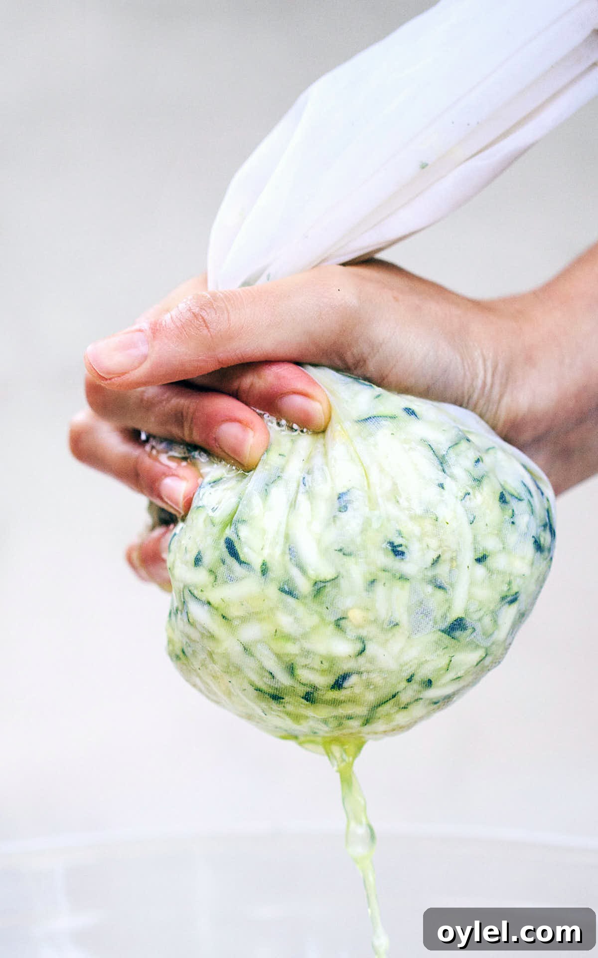 Squeezing excess water from zucchini with milk cloth bag
