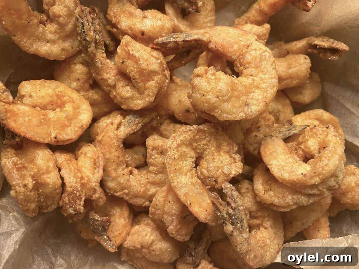 A pile of southern fried shrimp on brown parchment paper.