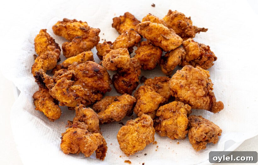Chicken nuggets after being fried on a paper towel lined plate.