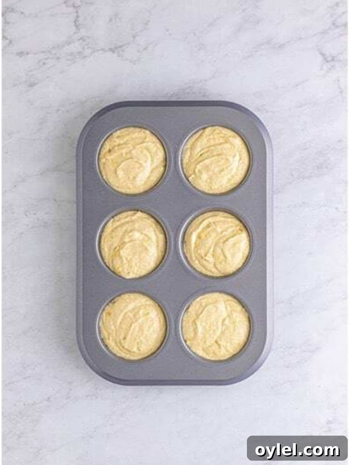 Dividing the cupcake batter into the prepared muffin tin.