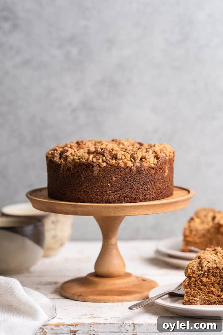 Authentic Spanish Coffee Cake Recipe 2 Spanish Coffee Cake on a wood cake stand with slices on the side.