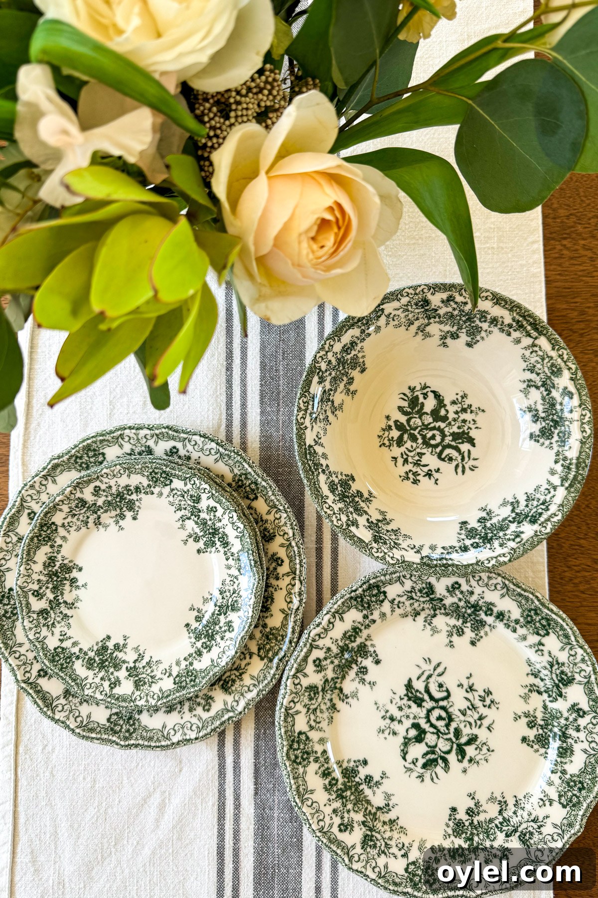 green floral plates and bowls on striped cloth with flowers