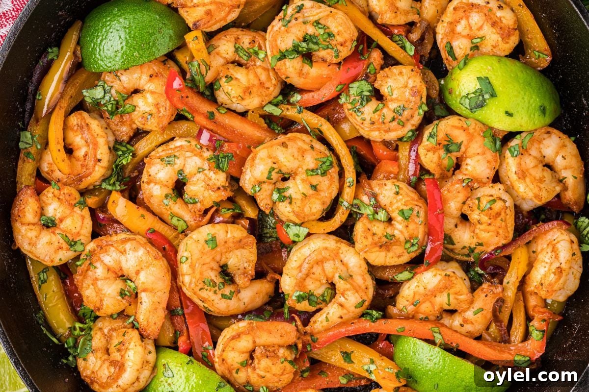 overhead view of shrimp, peppers, and limes in cast iron skillet.