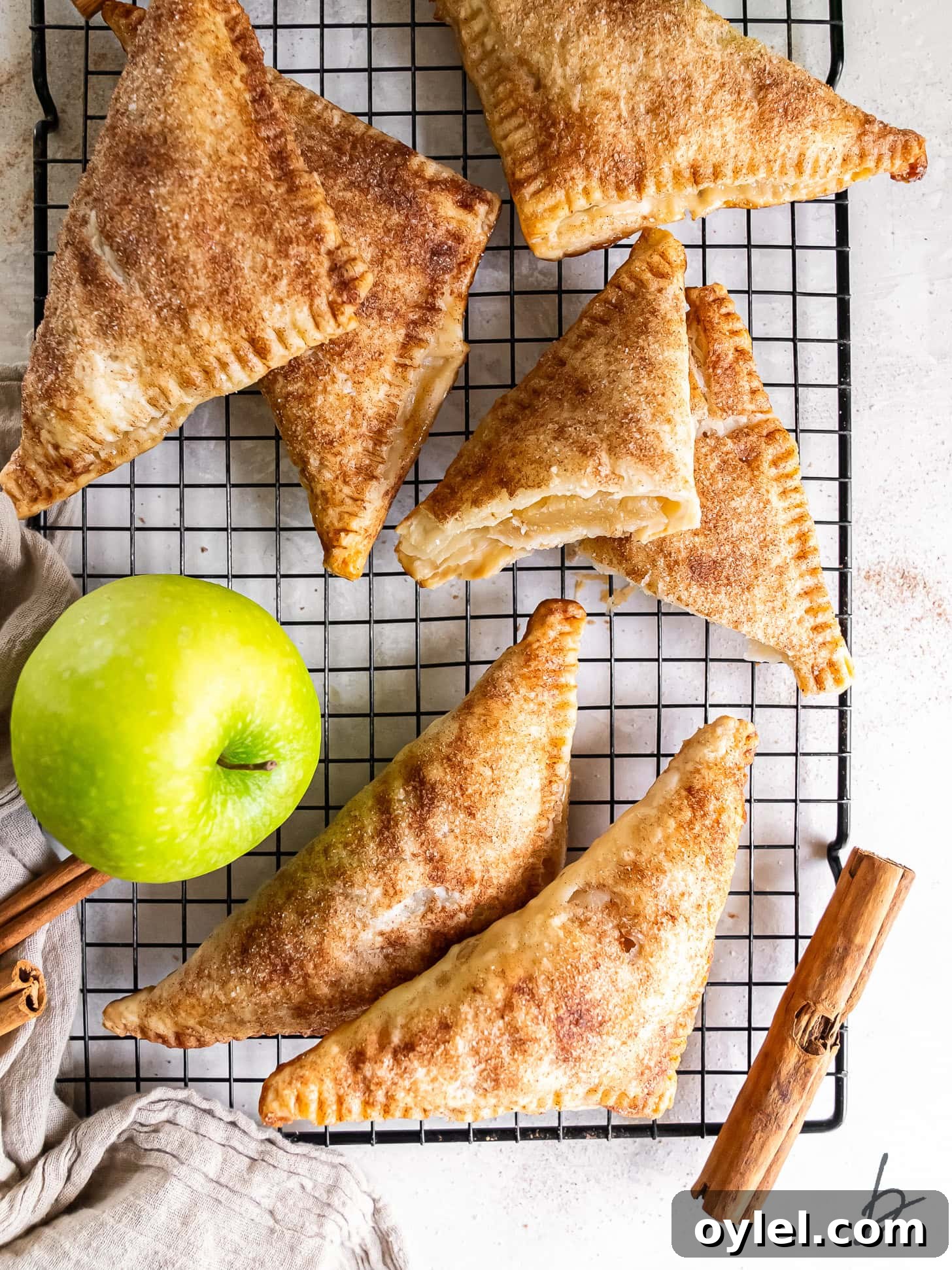 Puff pastry apple turnovers on a wire rack.