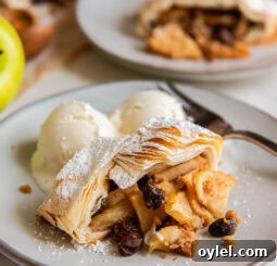 slice of apple strudel on a plate with vanilla ice cream.