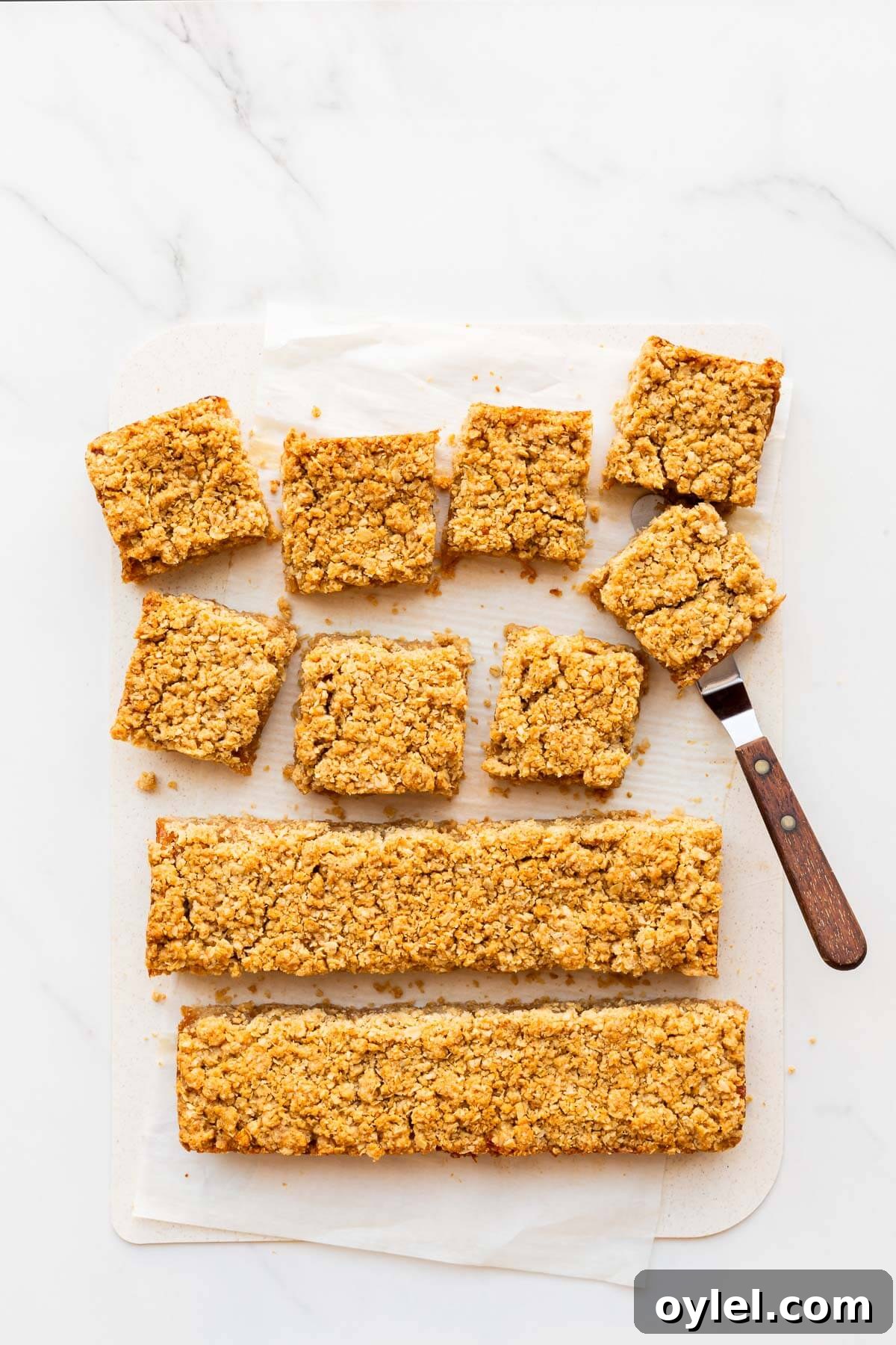 Apple Crisp Bars Recipe with Oat Streusel 6 Slicing applesauce oatmeal bars into squares to serve them.