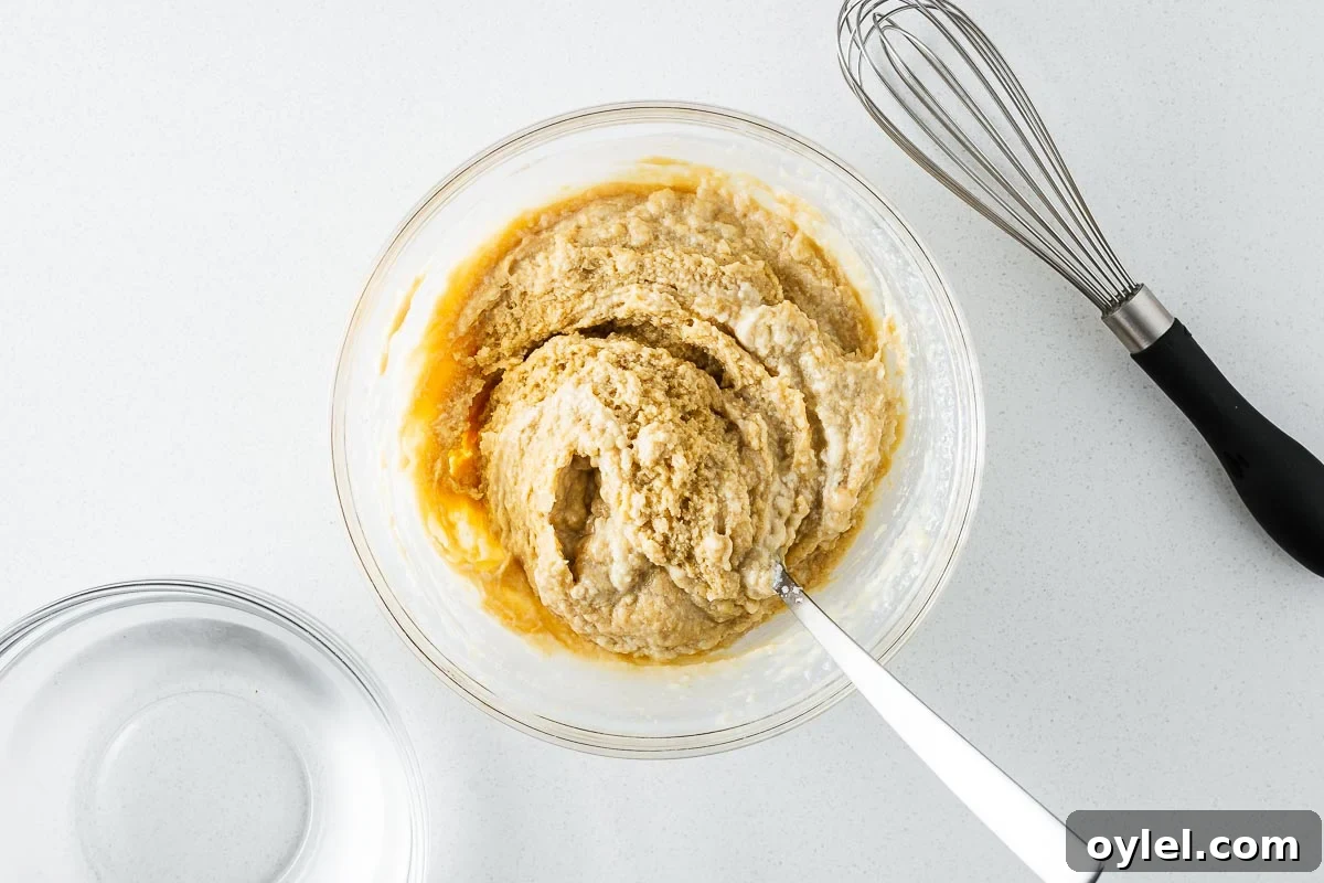 Lemon Tahini Sauce Recipe: 5 Flavor Variations 5 Tahini sauce seizing in a glass bowl when liquid is stirred into it, as viewed from above.