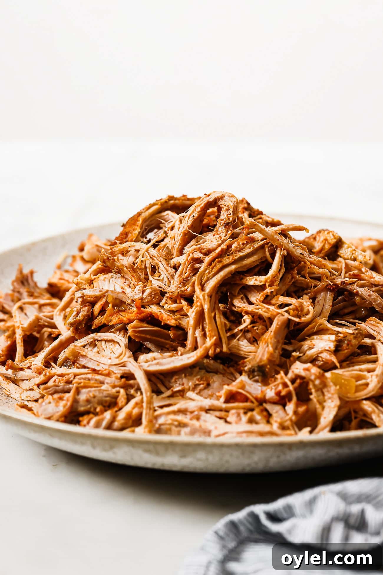 Slow cooker pulled pork piled on a serving plate. 