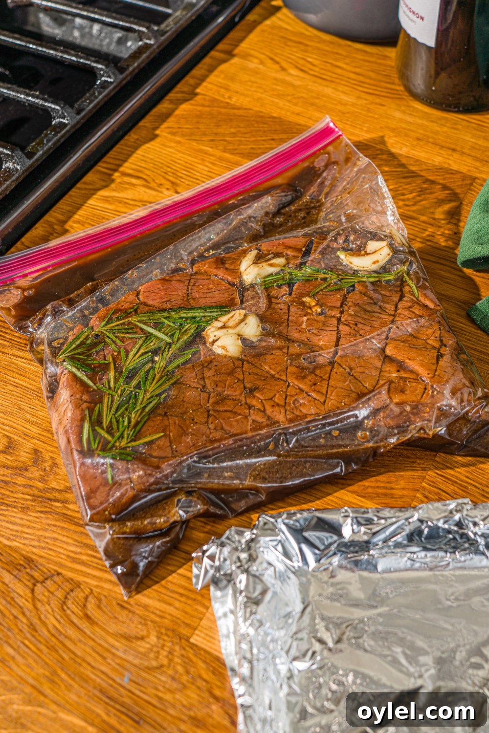 London Broil Marinade Recipe for Tender, Flavorful Steak 7 A London broil beef scored in a diagonal pattern in a ziploc bag marinating in London broil marinade. The bag is on a wooden counter.