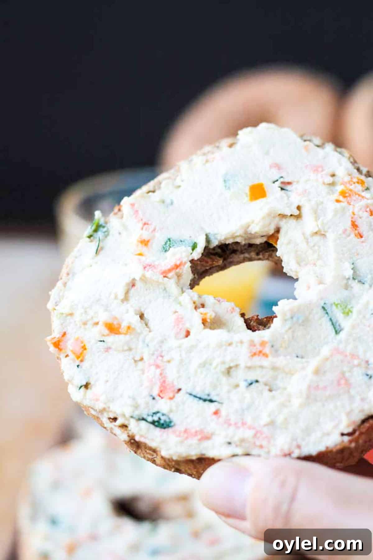 Handle holding one half of a bagel with spread.