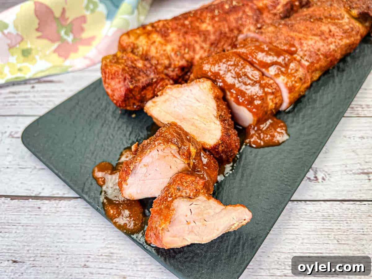 A plate of Ninja Woodfire Outdoor Grill-Smoked Pork Tenderloin with Mezcal BBQ Sauce.