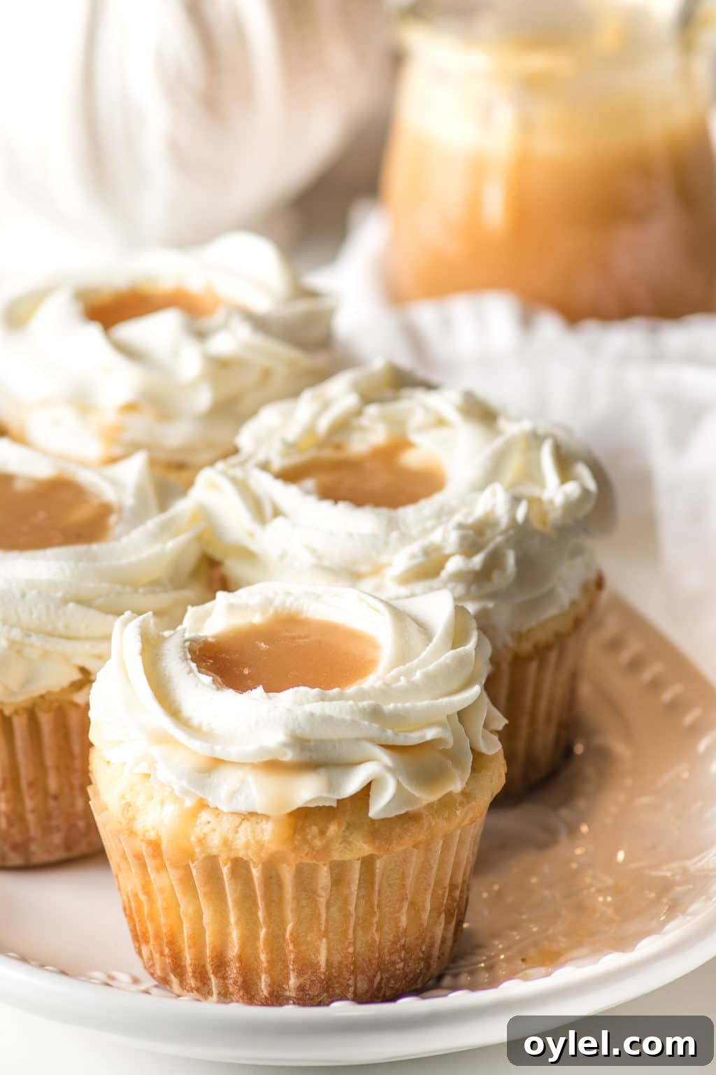 Closeup of keto salted caramel cupcakes, with a pool of caramel nestled in the frosting.