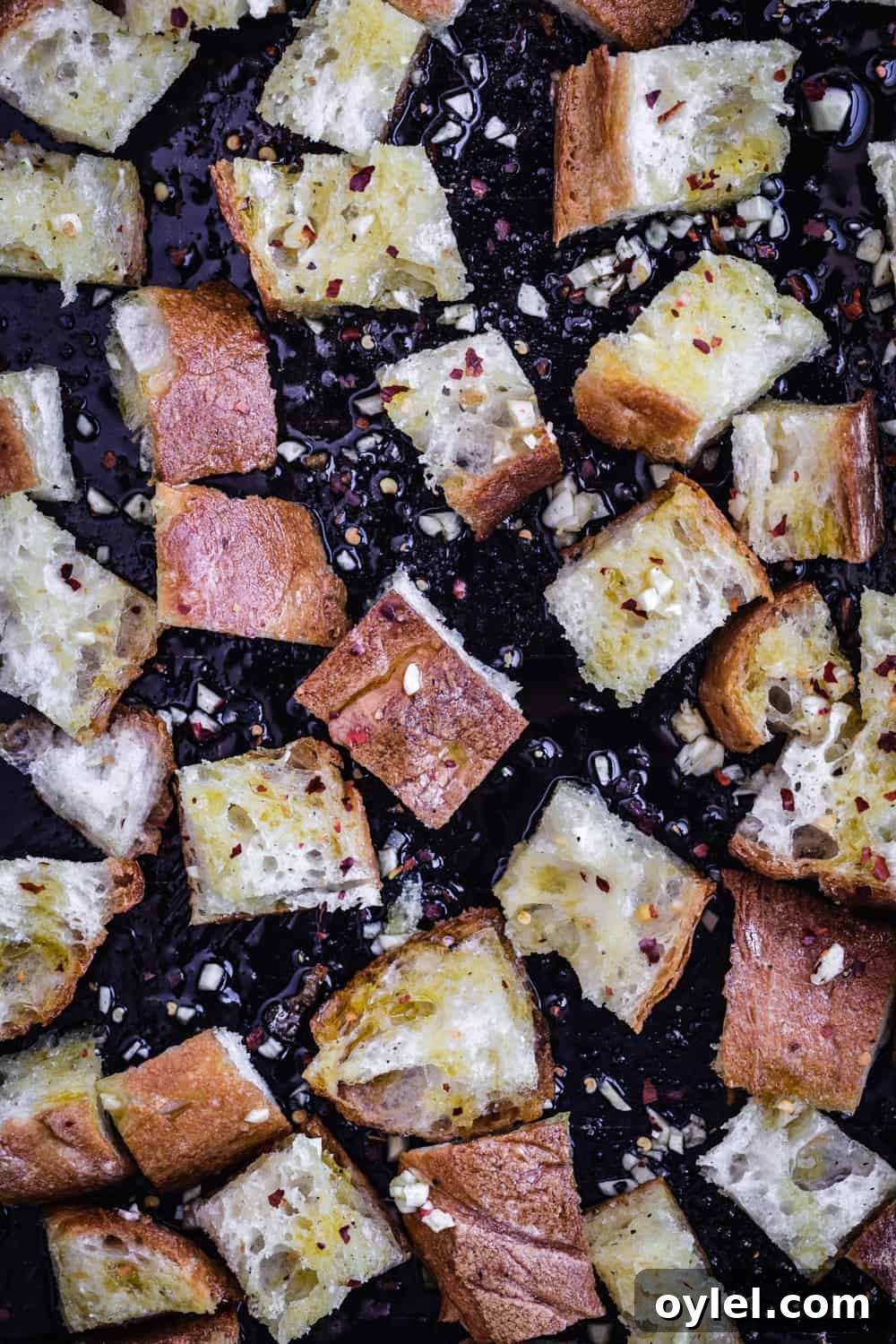 Croutons in the making - bread tossed with olive oil, garlic and chili flakes.