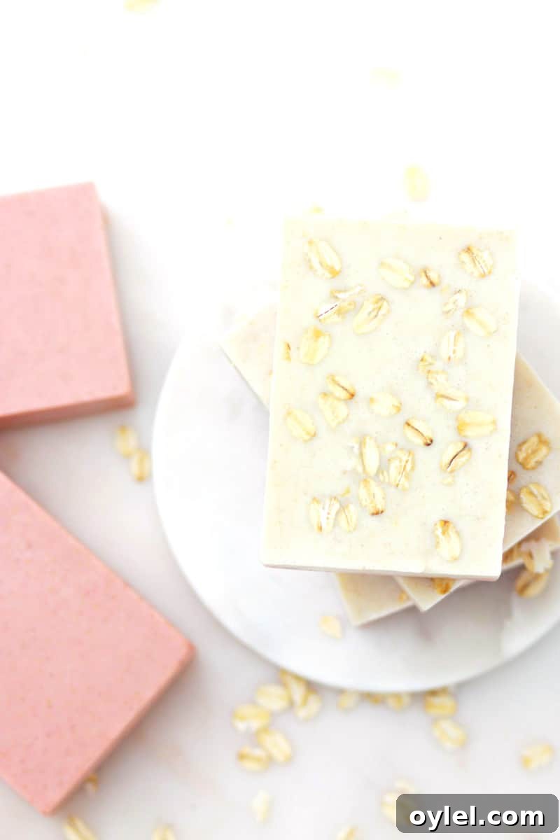 handmade oatmeal soaps with pink clay mixed in laying on a marble soap dish