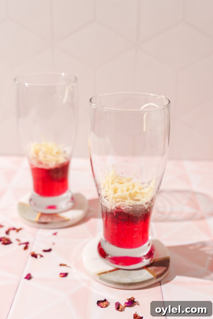 layering the falooda with rose syrup, sabja seeds and noodles.