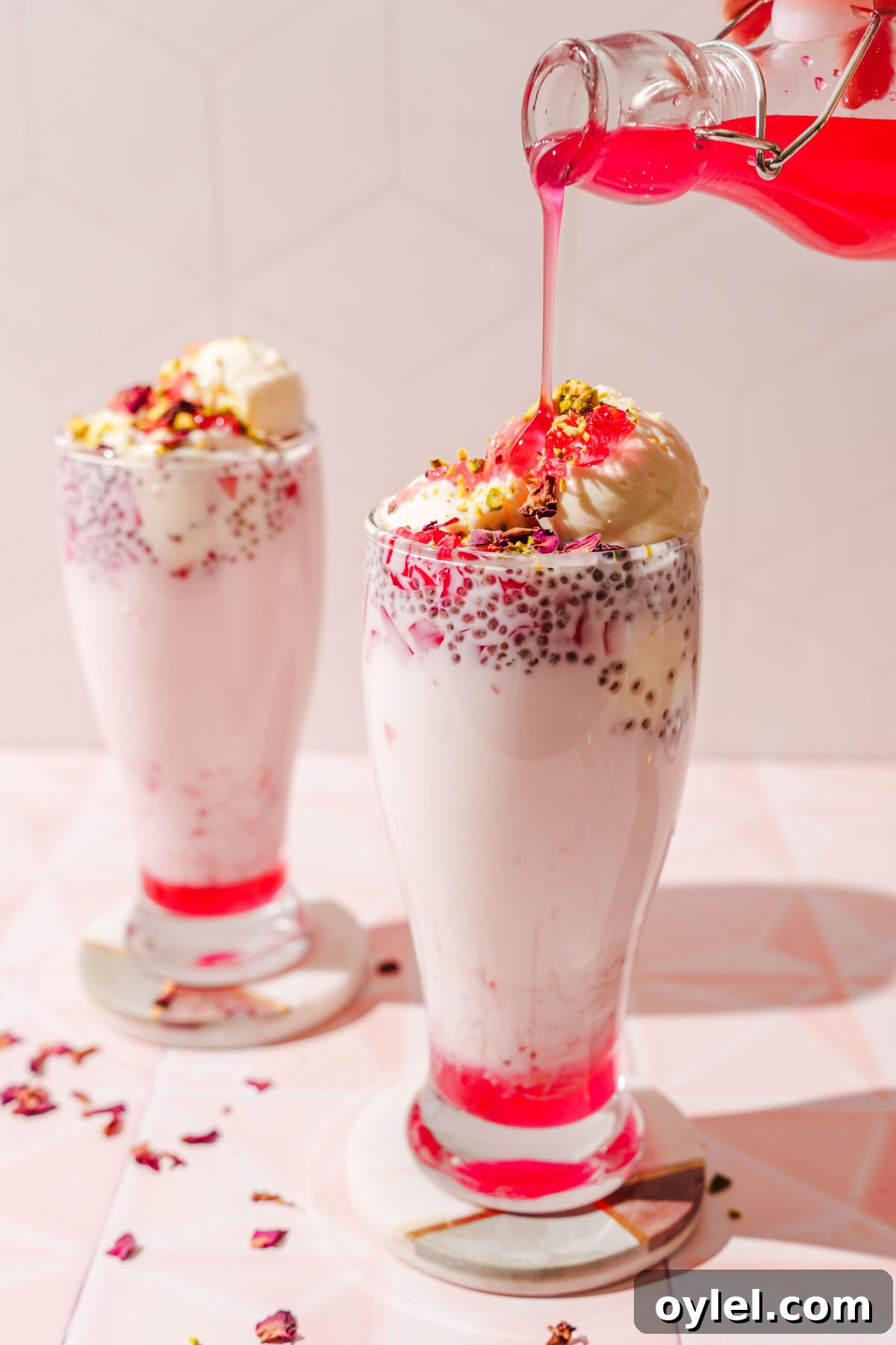 falooda with rose syrup being poured over.