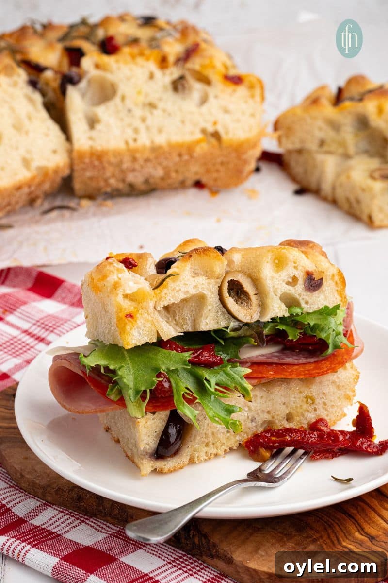 Sourdough Focaccia Recipe: Crispy Crust, Airy Interior 2 A slice of bread on a white plate with fork.