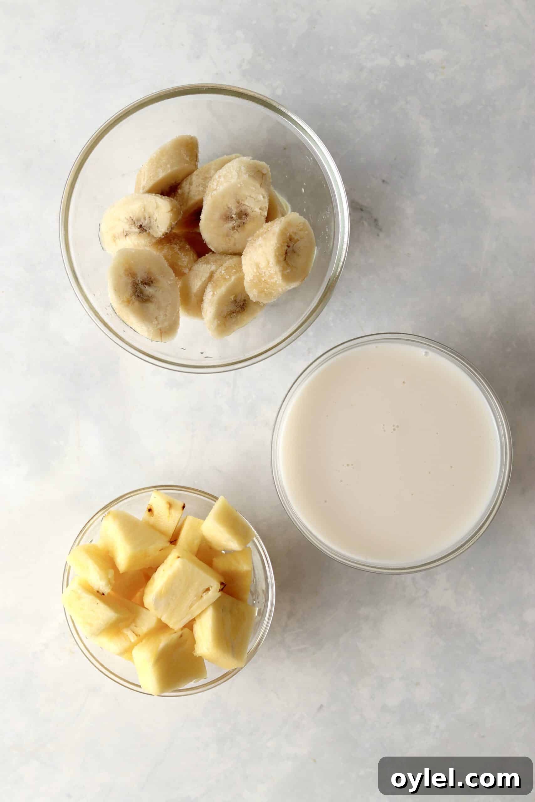 Creamy Tropical Vegan Banana and Pineapple Smoothie 3 frozen banana, pineapple chunks, and almond milk in bowls