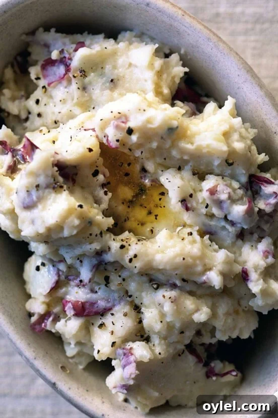 A baking dish filled with mashed potatoes that are sprinkled with black pepper