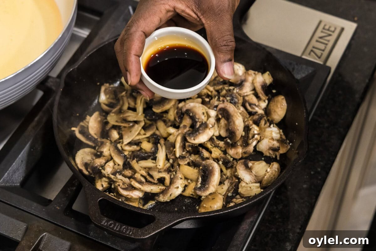 Sauteed Mushrooms with Garlic and Thyme Recipe 8 adding soy sauce to mushrooms and garlic in skillet