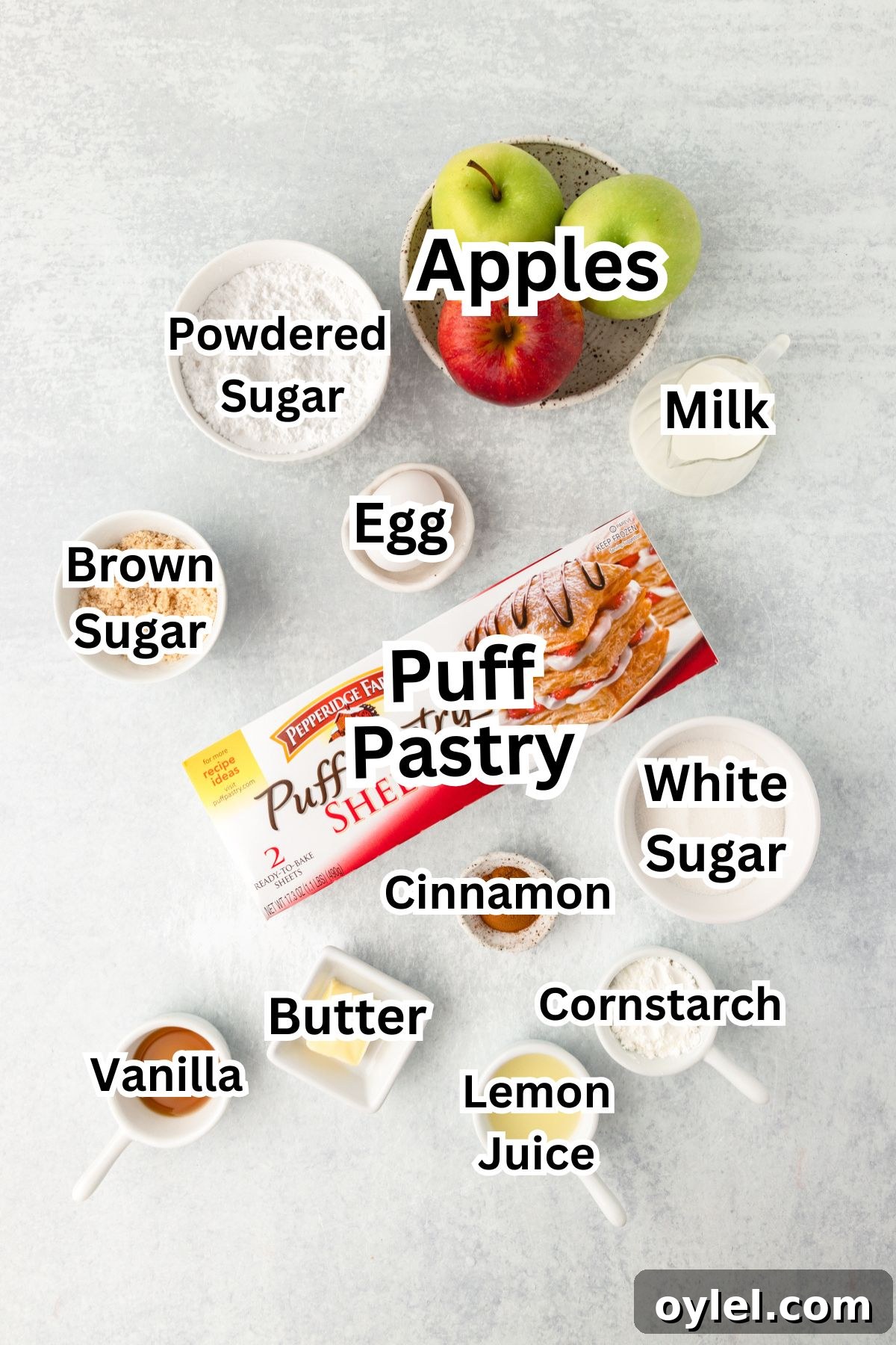 Flaky Puff Pastry Apple Turnovers Recipe 3 Flat lay of labeled baking ingredients, including apples, puff pastry, sugars, cinnamon, butter, and more.