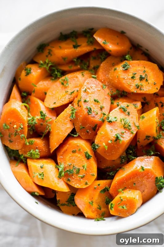 White bowl containing carrots, topped with parsley.