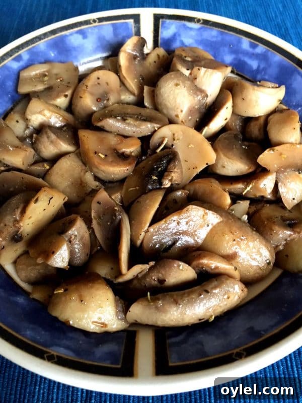 Blue bowl containing sauteed mushrooms cooked in an Instant Pot topped with fresh ground pepper.