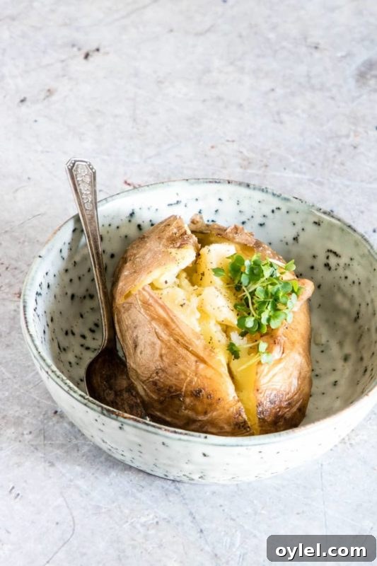 Baked Potato cooked in an Instant Pot sitting in a bowl on a white counter.