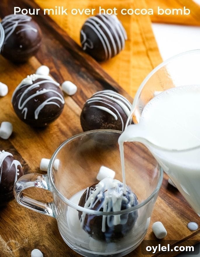 pouring milk over a hot chocolate bomb in a glass mug