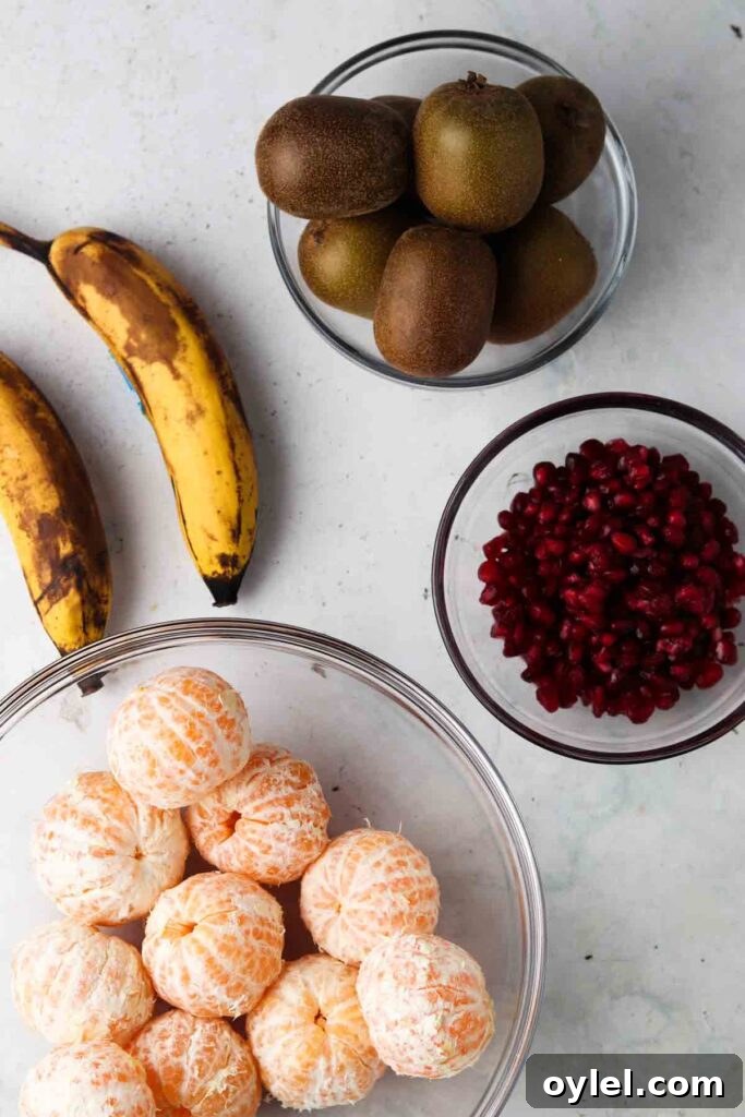 clementines, pomegranate, kiwi and bananas in bowls