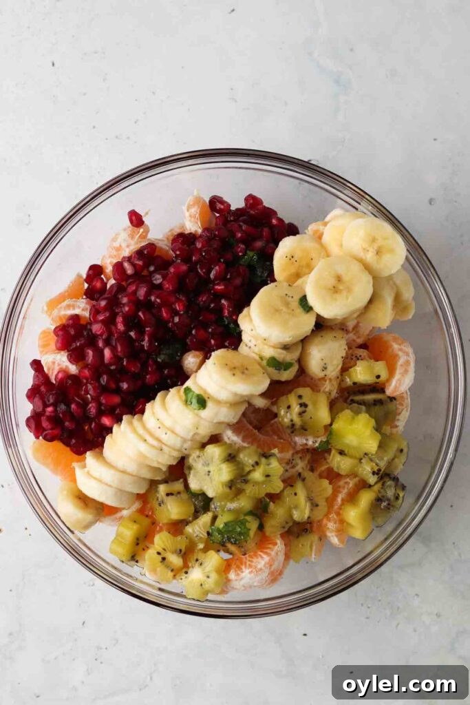 pomegranate, mint, bananas, and kiwi in a bowl