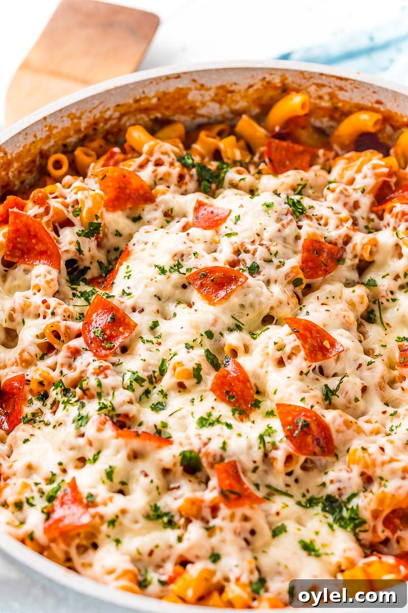 Close up photo of pasta cookies with pepperoni, cheese, and red sauce.