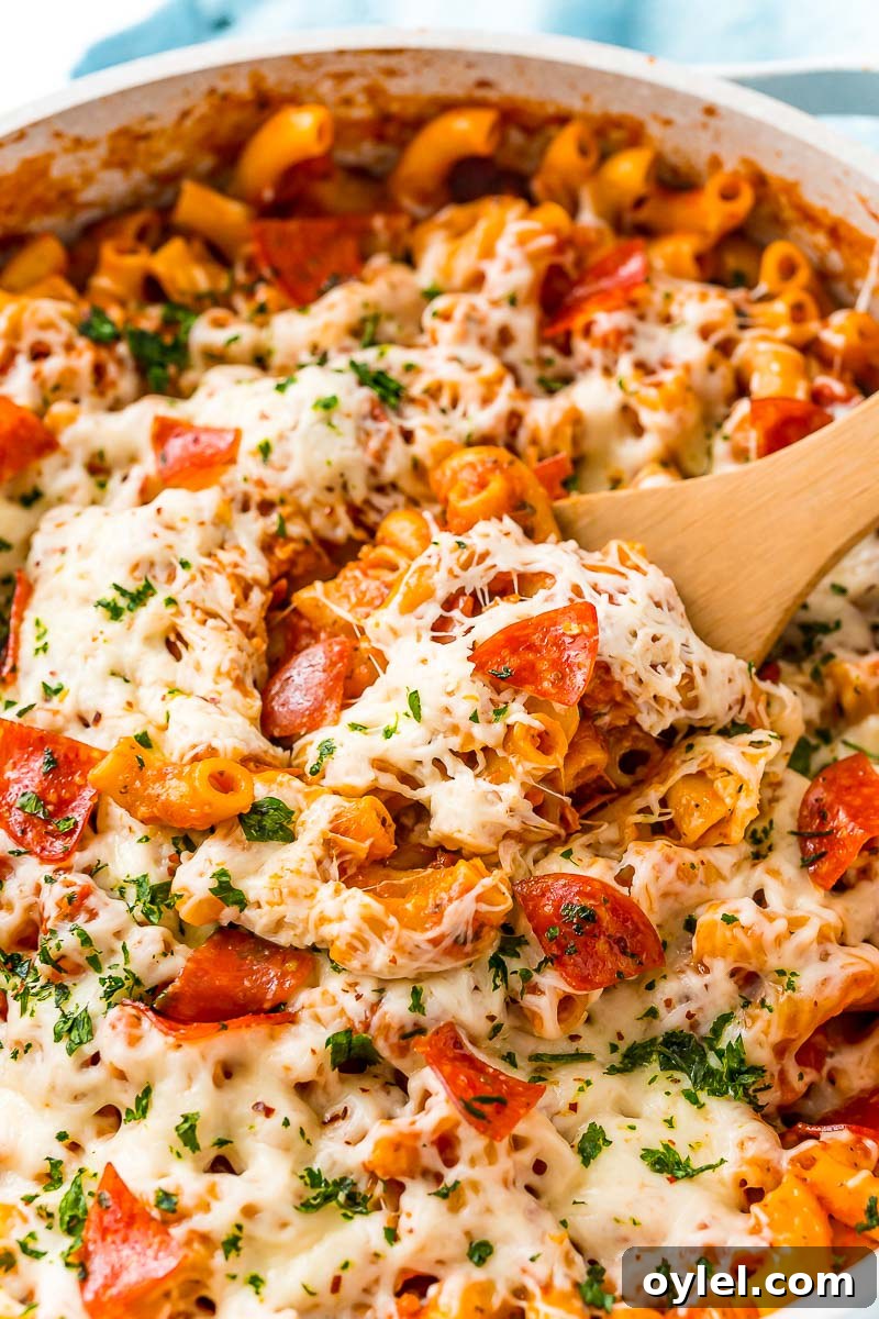 Close up photo of pizza pasta with a wooden serving spoon.
