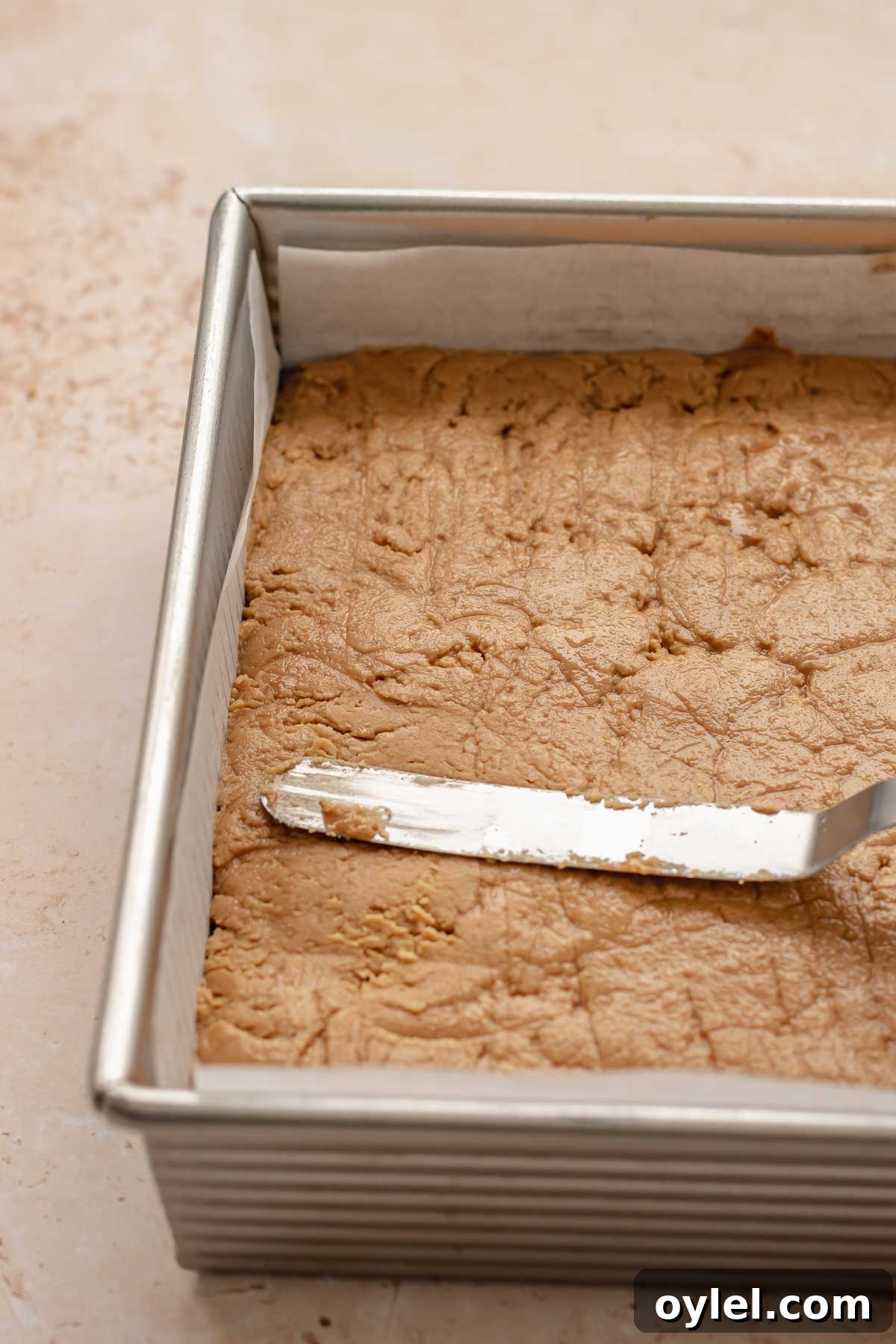 A spatula smooths the fudge flat.